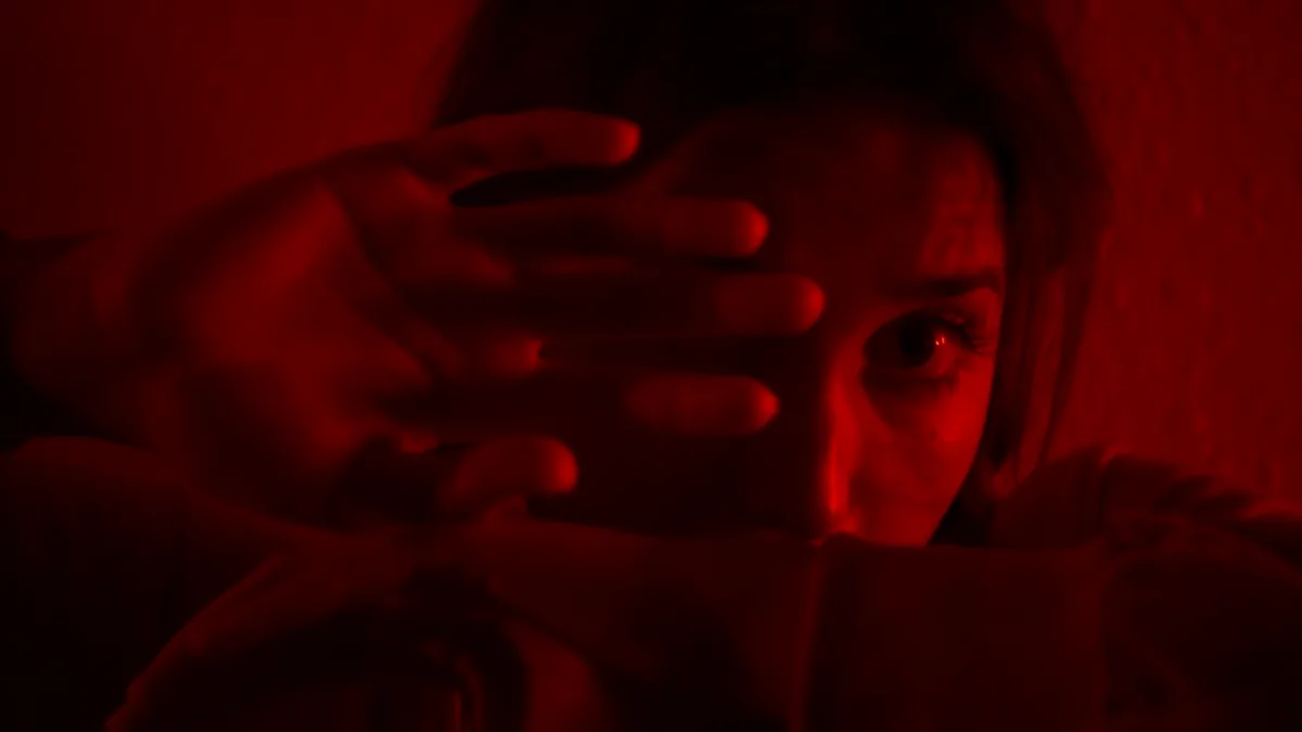 Red-lit frame from Real Connections showing intimate visual work.